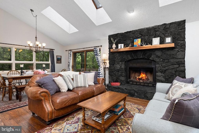 589 Pedlars Edge Dr, Roseland, VA 22967 - living room featuring a chandelier, wood finished floors, high vaulted ceiling, a fireplace, and a skylight
