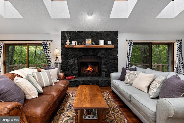 589 Pedlars Edge Dr, Roseland, VA 22967 - living area with a skylight, wood finished floors, a textured ceiling, vaulted ceiling, and a stone fireplace