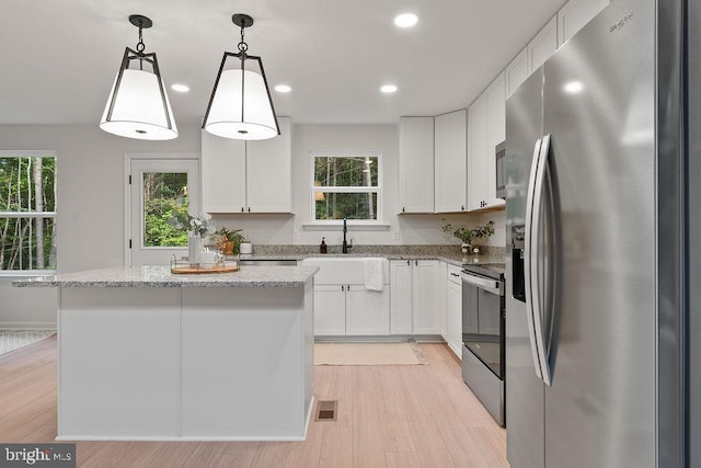 5831 Stubbs Bridge Rd, Mineral, VA 23117 - kitchen featuring appliances with stainless steel finishes, light wood finished floors, white cabinetry, a kitchen island, and recessed lighting