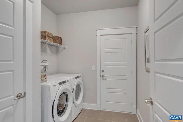 laundry room featuring light tile patterned floors, baseboards, washing machine and dryer, and laundry area