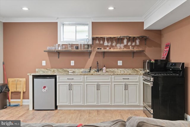 519 Cardinal Ln, Warrenton, VA 20186 - indoor wet bar featuring stainless steel gas stove, refrigerator, black microwave, ornamental molding, and light wood finished floors