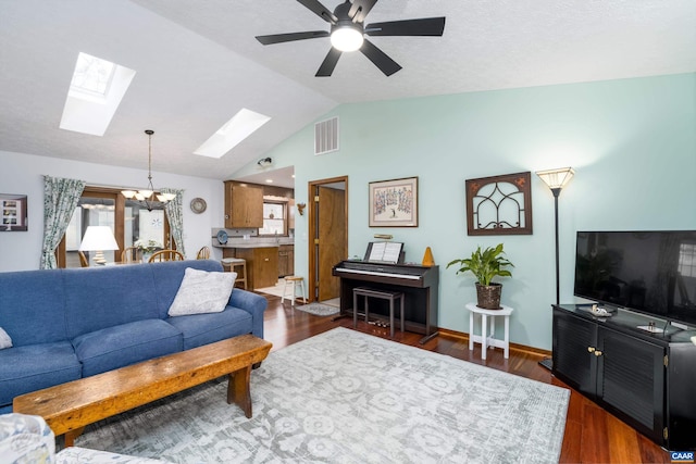 609 Jefferson Dr, Palmyra, VA 22963 - living area with lofted ceiling with skylight, dark wood finished floors, visible vents, and ceiling fan with notable chandelier