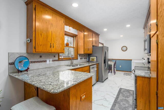 609 Jefferson Dr, Palmyra, VA 22963 - kitchen featuring a sink, a peninsula, marble finish floor, brown cabinets, and appliances with stainless steel finishes