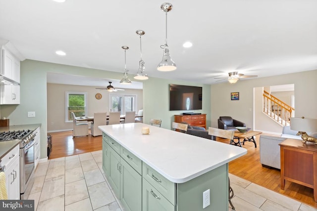 13001 Country View Ln, Amissville, VA 20106 - kitchen with gas range, a ceiling fan, green cabinets, a center island, and light countertops