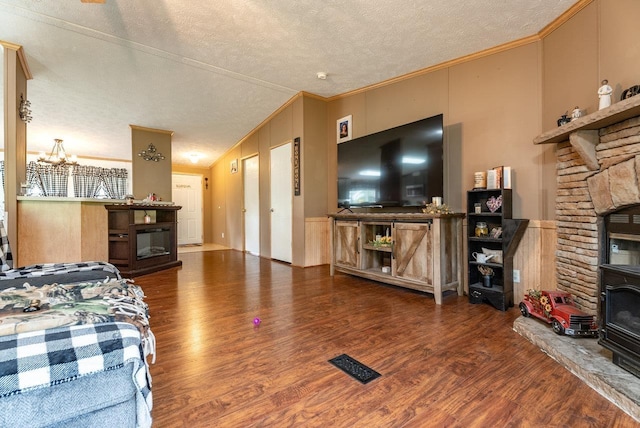 3930 Williams Ln, Elkton, VA 22827 - living room with a fireplace, wood finished floors, vaulted ceiling, a textured ceiling, and ornamental molding