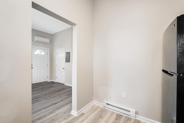 entrance foyer featuring wood finished floors, a wall mounted AC, baseboards, and a baseboard heating unit