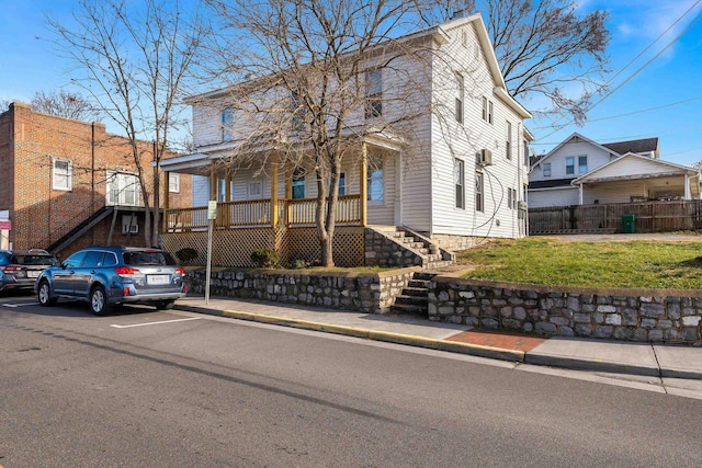 view of front of house featuring a front yard, stairway, a porch, and fence