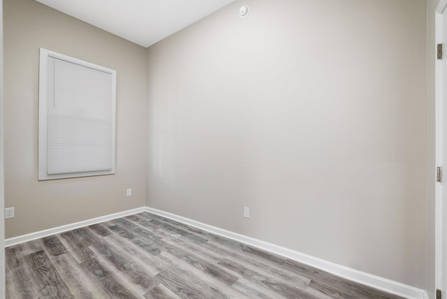spare room with wood finished floors and baseboards