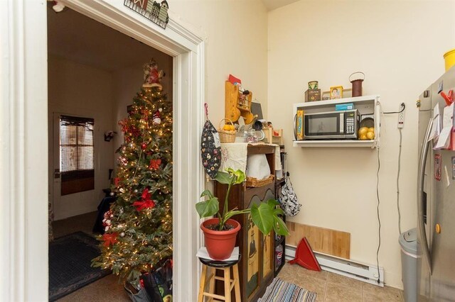 interior space with a baseboard heating unit and stainless steel microwave