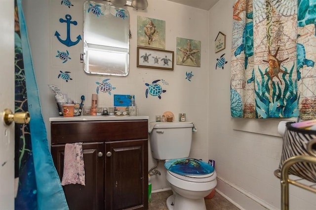 bathroom with toilet, tile patterned flooring, and vanity