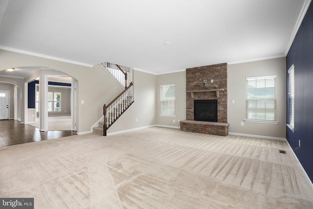 6056 Greenspring Rd, Fredericksburg, VA 22407 - unfurnished living room featuring carpet floors, ornamental molding, plenty of natural light, arched walkways, and a stone fireplace