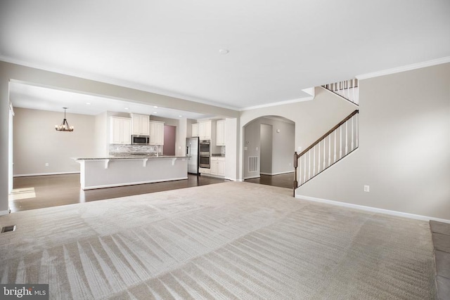 6056 Greenspring Rd, Fredericksburg, VA 22407 - living area featuring baseboards, ornamental molding, arched walkways, stairway, and a chandelier