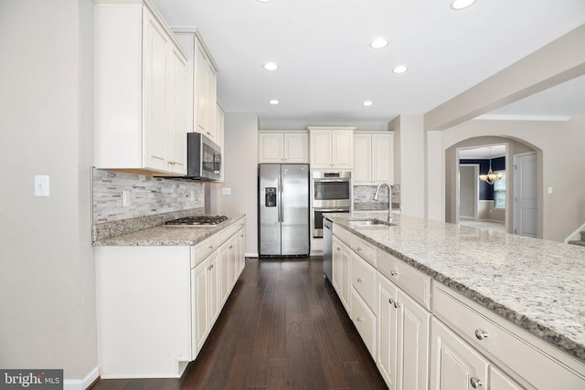 6056 Greenspring Rd, Fredericksburg, VA 22407 - kitchen featuring appliances with stainless steel finishes, a sink, backsplash, arched walkways, and recessed lighting