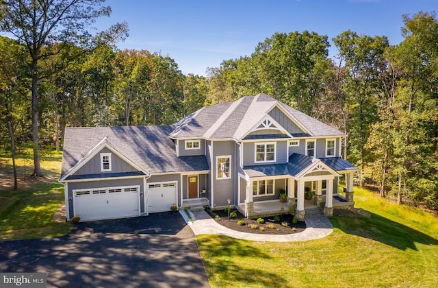 view of front of home featuring board and batten siding, asphalt driveway, an attached garage, and a standing seam roof