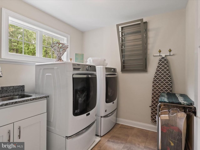 washroom with washer and clothes dryer and baseboards