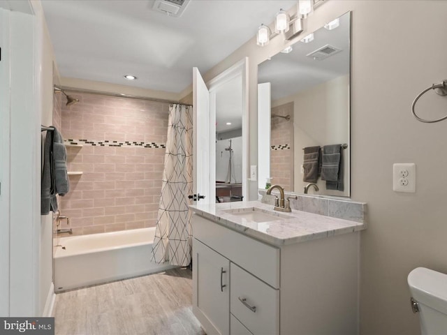 full bath featuring toilet, wood finished floors, vanity, shower / tub combo with curtain, and recessed lighting