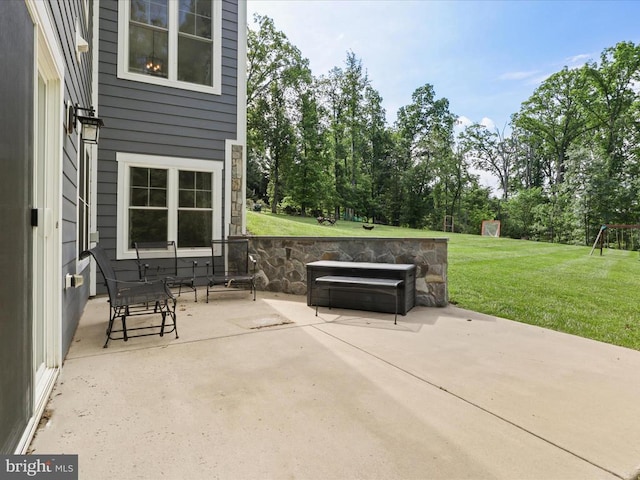 view of patio / terrace with a playground and view of wooded area