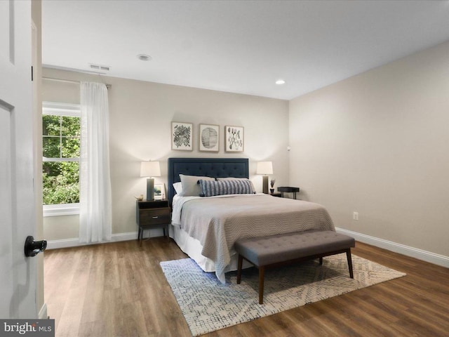bedroom with baseboards, wood finished floors, and recessed lighting