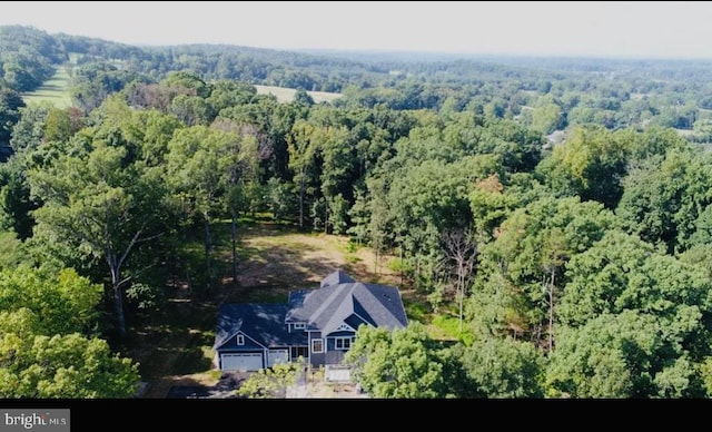 view from above of property with a heavily wooded area