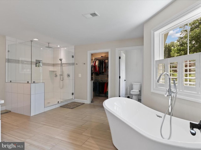 full bath with a shower stall, a freestanding bath, a walk in closet, and recessed lighting
