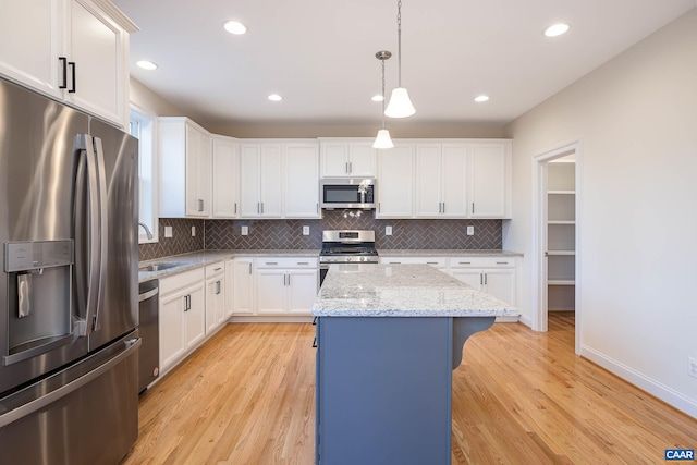 212 Bartholomew Pl, Stanardsville, VA 22973 - kitchen with light wood finished floors, appliances with stainless steel finishes, a center island, and decorative backsplash