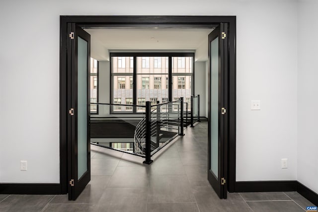 corridor featuring baseboards and an upstairs landing
