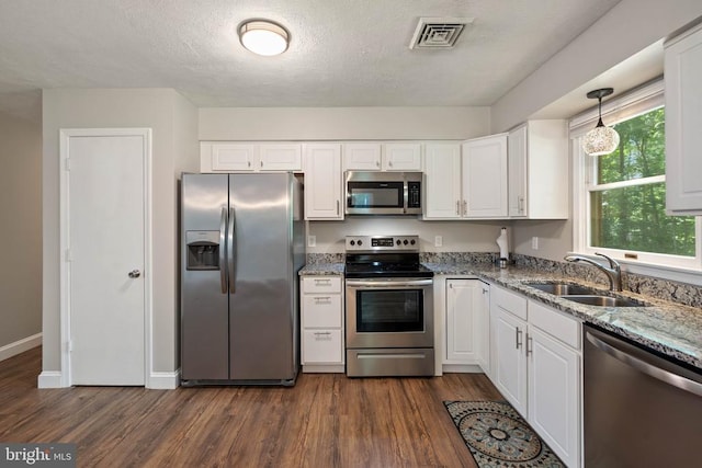 11248 Saint Pauls Rd, Remington, VA 22734 - kitchen featuring appliances with stainless steel finishes, dark wood-type flooring, white cabinetry, light stone counters, and a textured ceiling