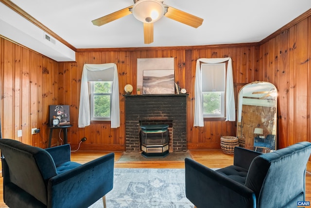 687 Gidsville Rd, Amherst, VA 24521 - living area with wood finished floors, a brick fireplace, a ceiling fan, wood walls, and crown molding