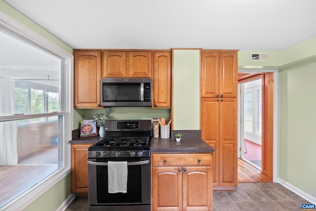 687 Gidsville Rd, Amherst, VA 24521 - kitchen with stainless steel microwave, gas stove, dark countertops, and baseboards