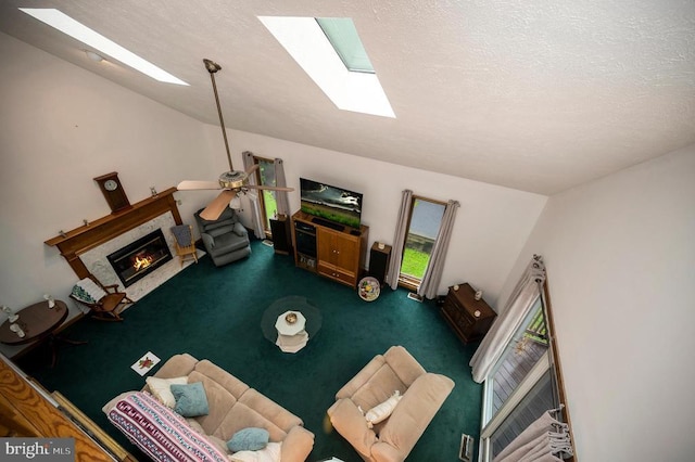 127 Gold Rush Dr, Locust Grove, VA 22508 - carpeted living room featuring a skylight, a glass covered fireplace, ceiling fan, and a textured ceiling