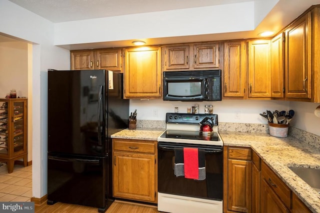127 Gold Rush Dr, Locust Grove, VA 22508 - kitchen featuring black appliances, brown cabinetry, light stone countertops, and light tile patterned flooring
