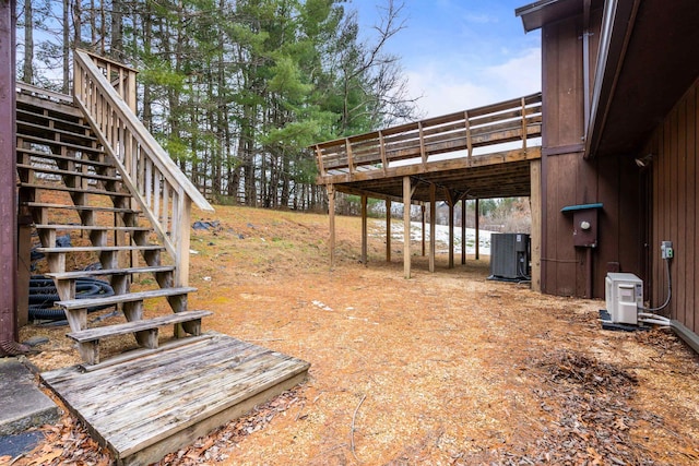 view of yard with central AC, a deck, and ac unit