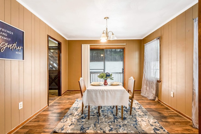 dining area featuring crown molding, a healthy amount of sunlight, a chandelier, and dark hardwood / wood-style flooring