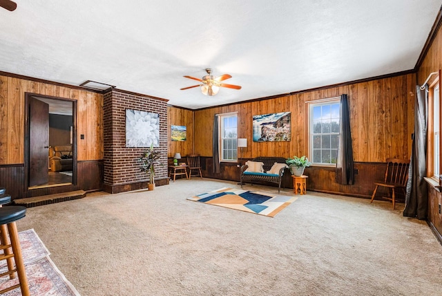 interior space with crown molding, ceiling fan, and wooden walls