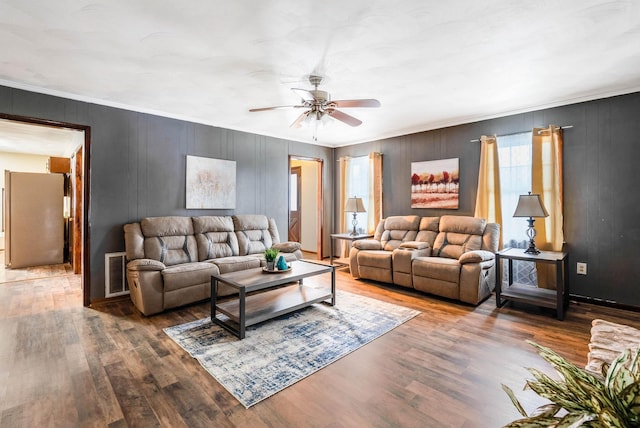 living room with hardwood / wood-style floors, crown molding, and ceiling fan