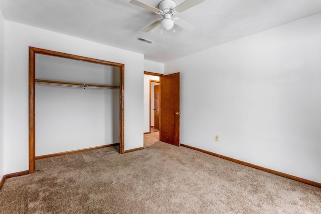 unfurnished bedroom with light colored carpet, a closet, and ceiling fan