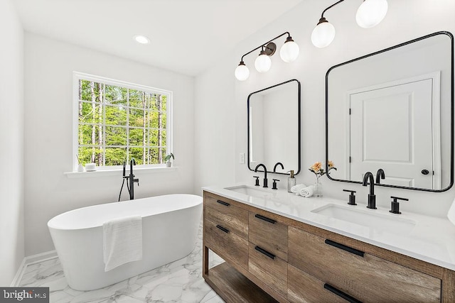 5903 Stubbs Bridge Rd, Mineral, VA 23117 - bathroom featuring marble finish floors, a soaking tub, double vanity, recessed lighting, and baseboards