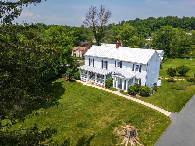 887 Natural Chimneys Rd, Mount Solon, VA 22843 - farmhouse-style home featuring covered porch, a chimney, a front lawn, metal roof, and a view of trees