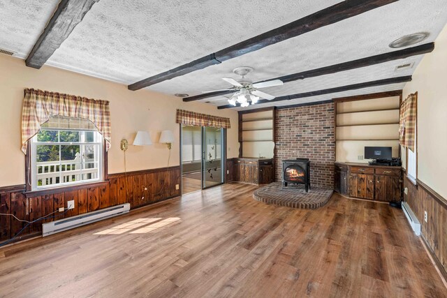 887 Natural Chimneys Rd, Mount Solon, VA 22843 - unfurnished living room with a baseboard heating unit, a textured ceiling, a wainscoted wall, beamed ceiling, and wood finished floors