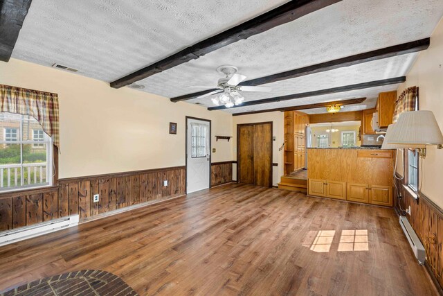 887 Natural Chimneys Rd, Mount Solon, VA 22843 - unfurnished living room with a baseboard heating unit, wood finished floors, beam ceiling, wainscoting, and a textured ceiling