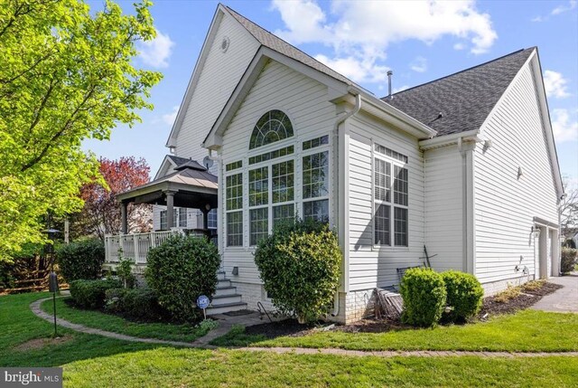  - view of front of home with a gazebo, a front lawn, a shingled roof, and driveway