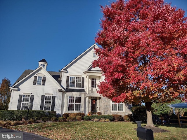  - view of front of home with a front lawn and stone siding