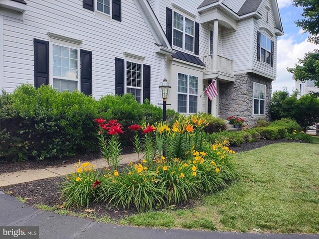  - view of side of property with stone siding and a yard