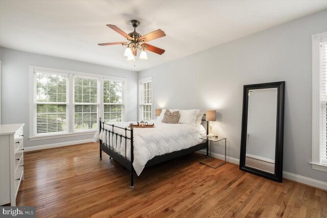  - bedroom featuring baseboards, wood finished floors, and ceiling fan