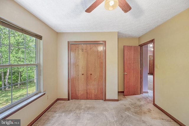 3716 Martin Kings Rd, Charlottesville, VA 22902 - unfurnished bedroom with multiple windows, light carpet, a closet, a textured ceiling, and ceiling fan