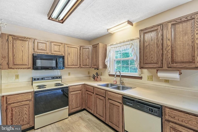 3716 Martin Kings Rd, Charlottesville, VA 22902 - kitchen featuring white appliances, a textured ceiling, light wood-style floors, brown cabinets, and light countertops