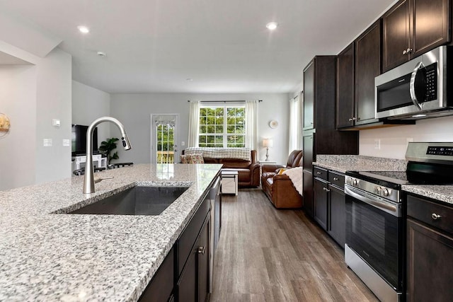 301 Willowshire Ct, Waynesboro, VA 22980 - kitchen with appliances with stainless steel finishes, open floor plan, wood finished floors, dark brown cabinets, and light stone countertops