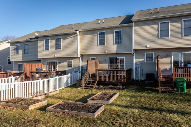 rear view of house featuring a wooden deck, a lawn, and central air condition unit