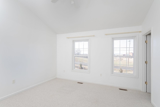 carpeted empty room featuring vaulted ceiling