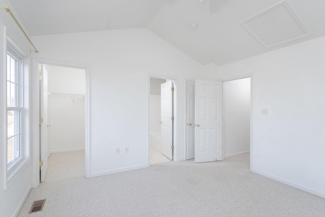 spare room featuring lofted ceiling and light colored carpet